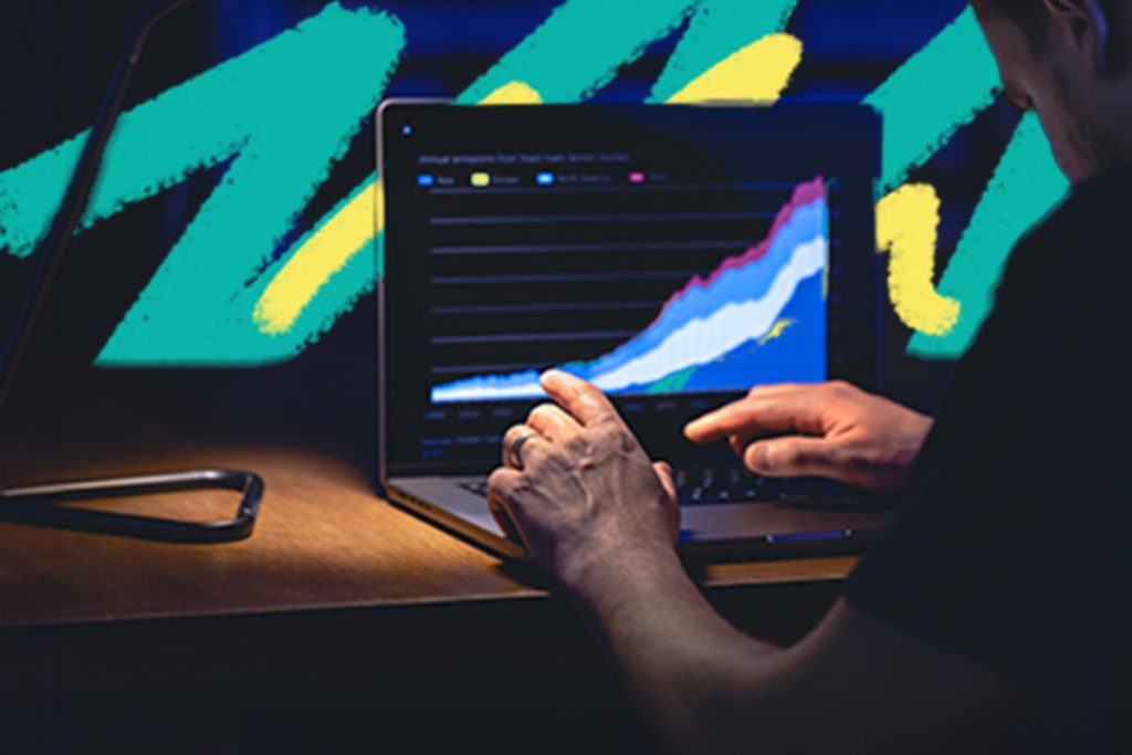 Man looking at data charts on a laptop.