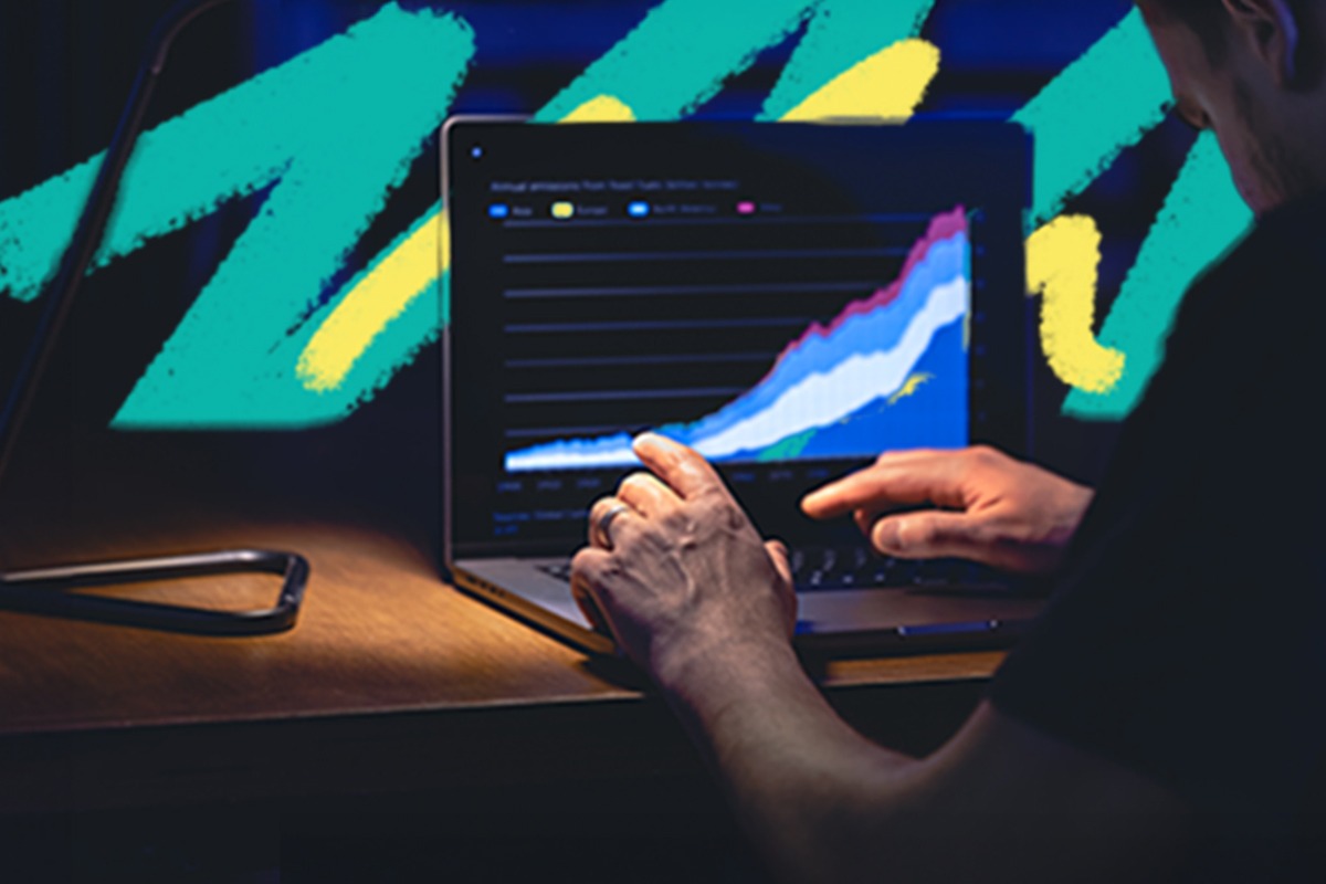 Man looking at data charts on a laptop.