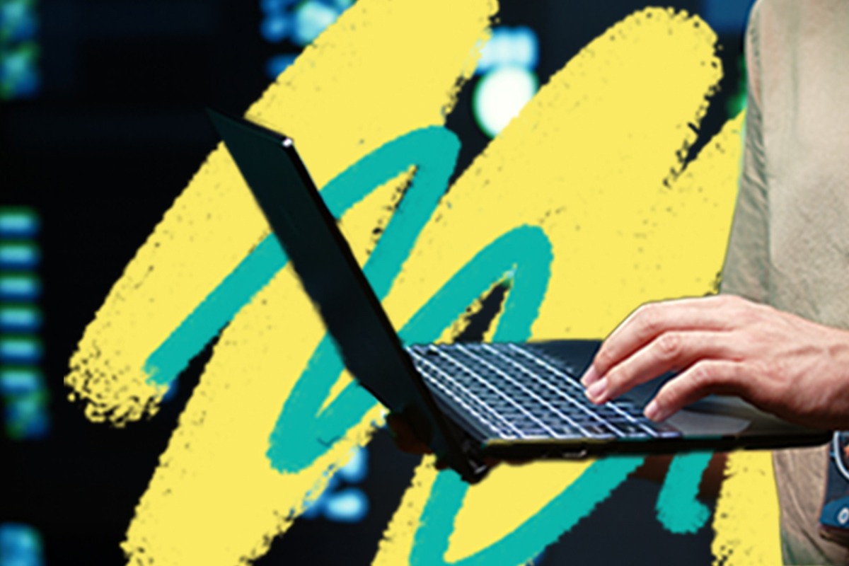 Man holding a laptop with their hands.